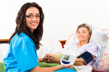 elderly woman lying on bed and a nurse